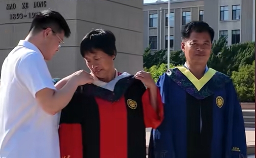 毕业典礼结束后，大工毕业生为父母换上自己的学位服一同拍照，用指尖一遍遍抚平衣襟，生怕一丝凌乱折损了此刻属于他们的荣光！